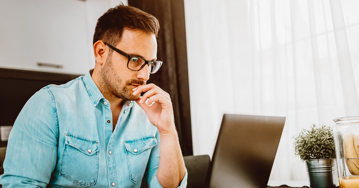 man in blue shirt concentrating on work